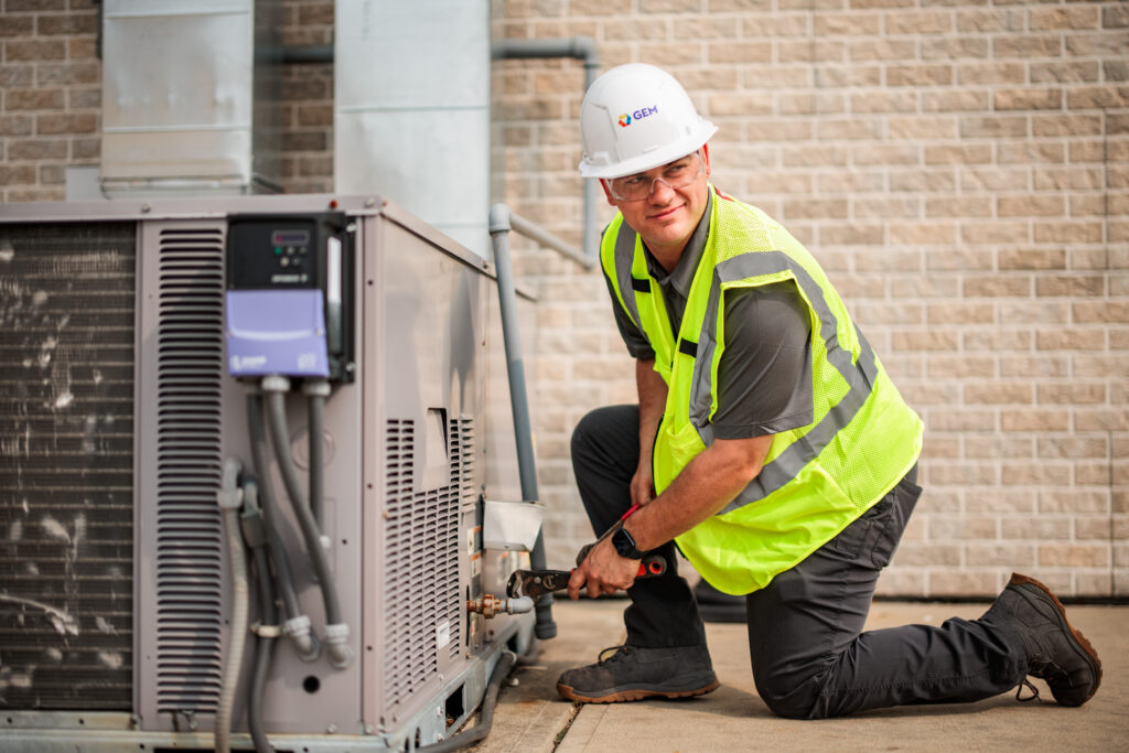 GEM commercial HVAC tech assessing and outdoor HVAC unit
