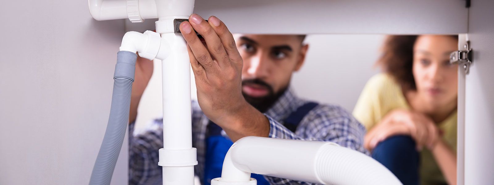 plumbing working under sink
