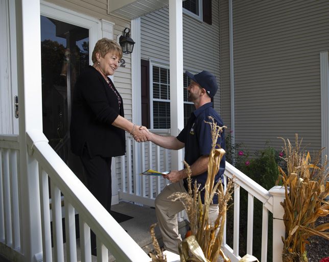 Customer and technician shaking hands on the front porch