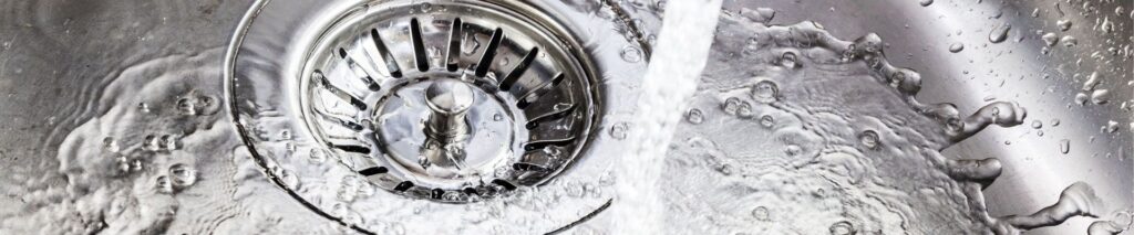 Water pouring into kitchen drain