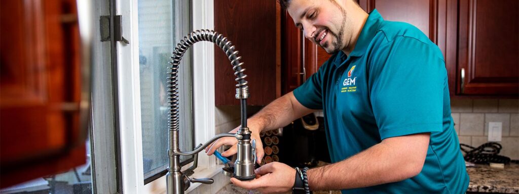 Plumber repairing kitchen faucet