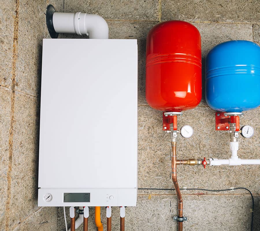 Boiler system on cinderblock wall in basement