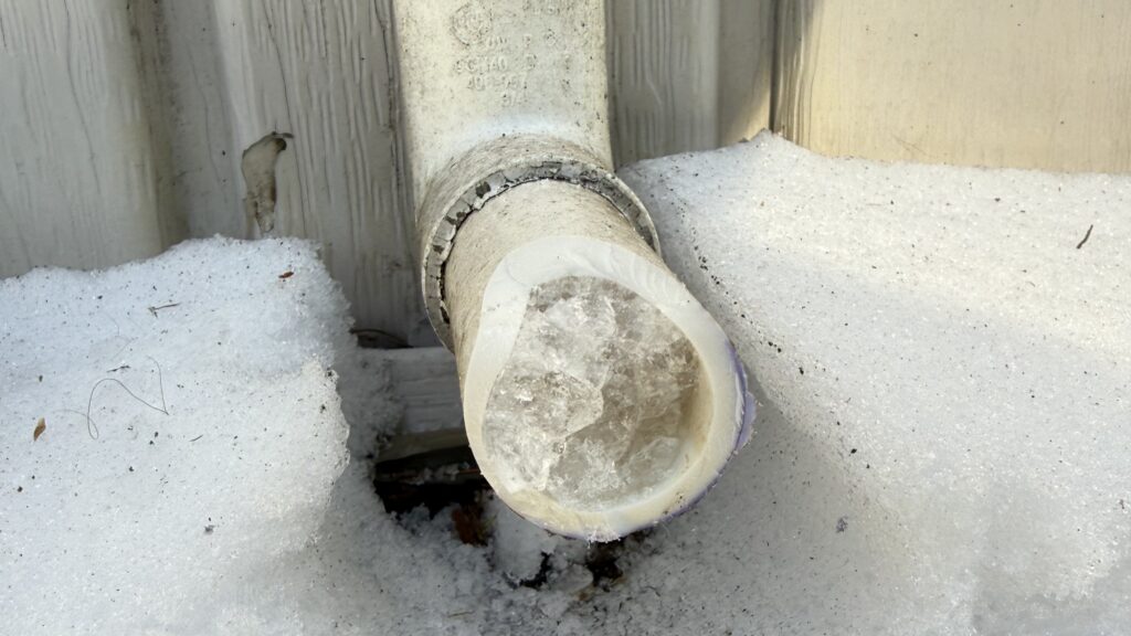 A frozen exterior PVC pipe is shown. GEM can provide tips for preventing frozen pipes during extreme cold in New England