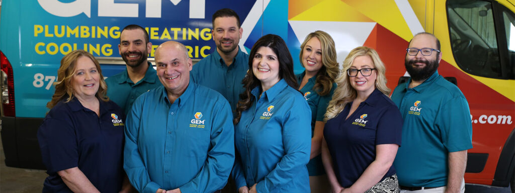 Gem employees stand in front of a branded truck smiling