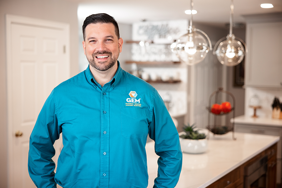 GEM technician smiling inside residential kitchen during service call