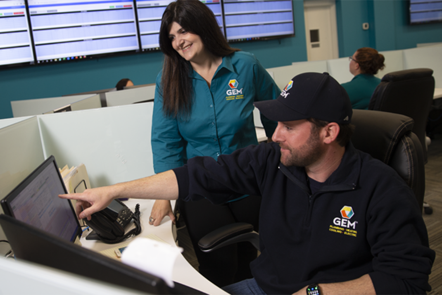 GEM technician working on indoor HVAC system with homeowner