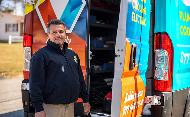 GEM technician standing beside branded service van