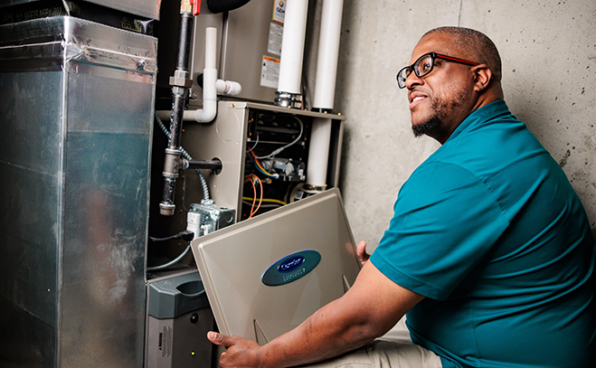 GEM HVAC technician inspecting indoor furnace system