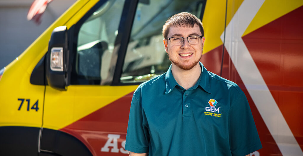 GEM HVAC technician standing in front of service van