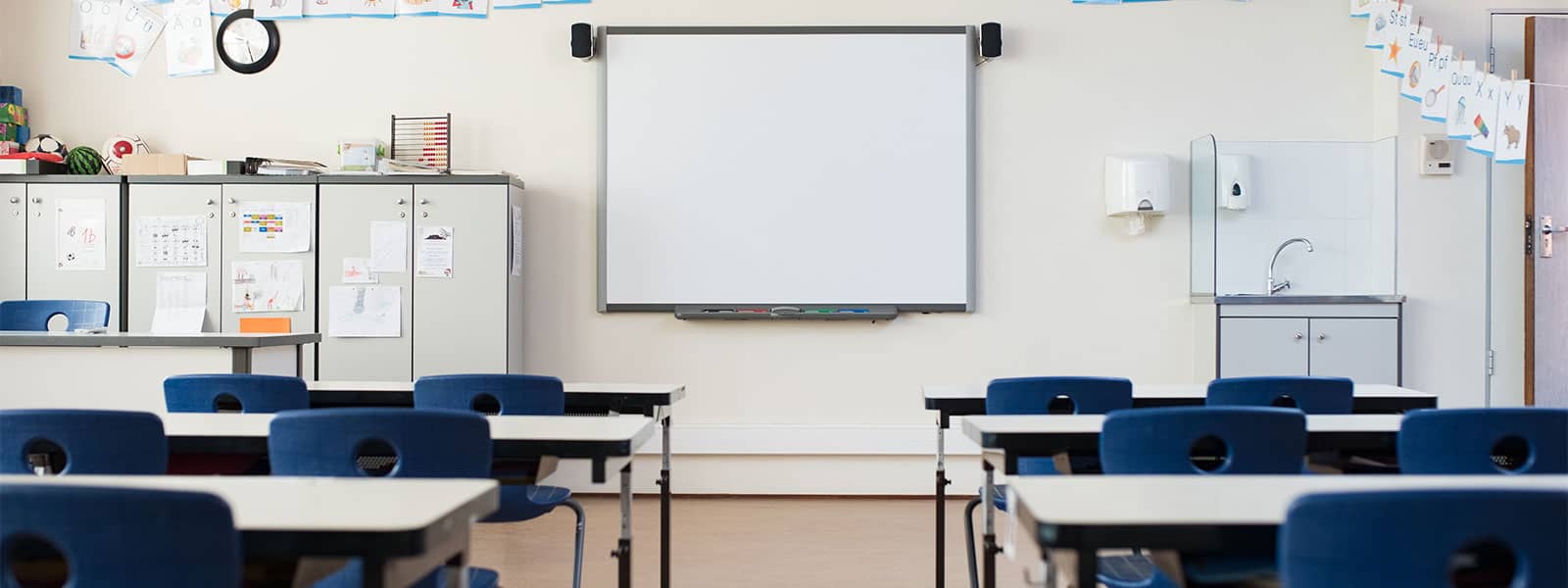 a service technician classroom with rows of tables and blue chairs and a white board