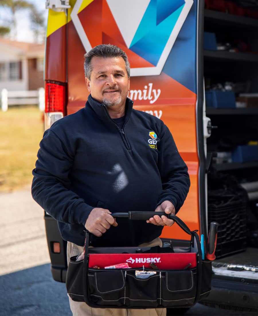 GEM technician with tool bag smiling in front of open truck