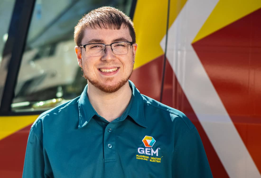 Young GEM technician standing in front of truck