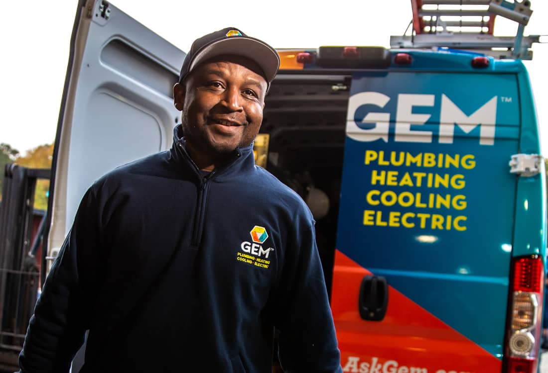 Smiling GEM technician loading truck at warehouse