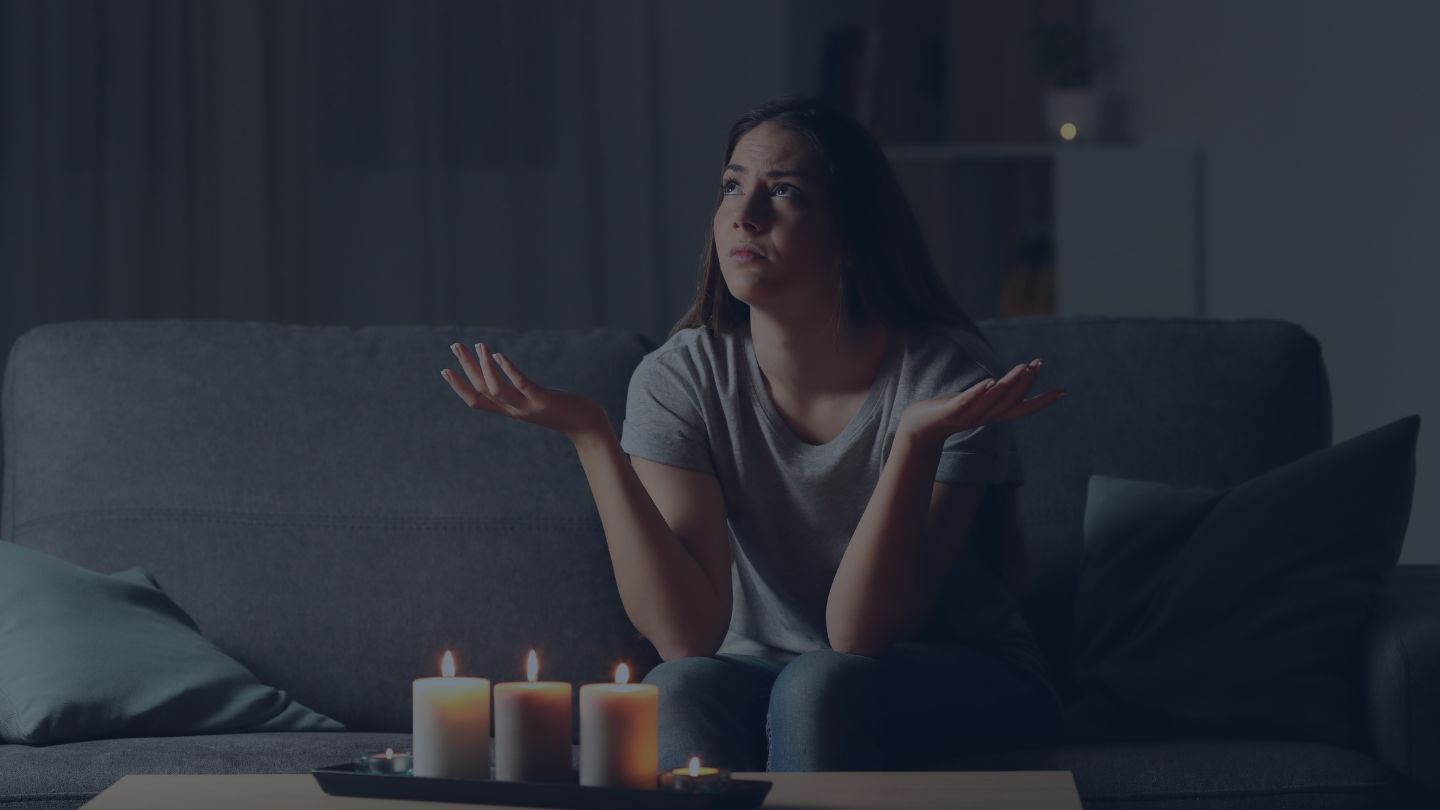 Woman sits in living room during power outage