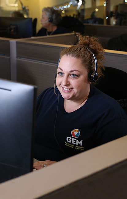 Customer service representative sitting at computer with headset on